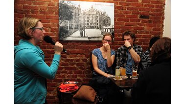 Eine Frau mit einem Mikrofon befragt zwei Zuhörer, die sich die Nase zuhalten.  | © Jens Rillke